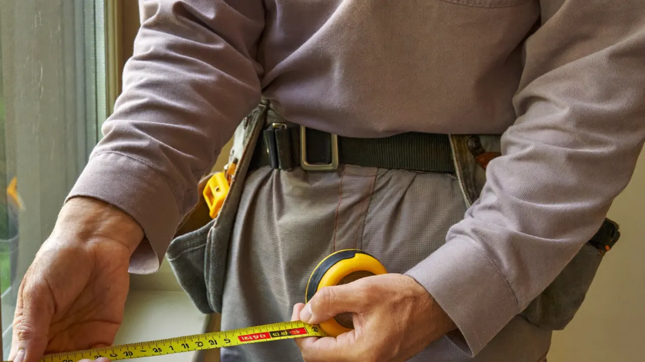 Surveyor measuring a window opening to prepare an accurate double glazing quote