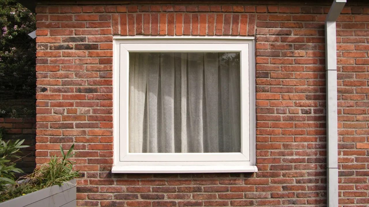 White uPVC casement window on the brick facade of a typical UK semi